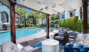 A poolside area with lounge chairs, a pool, and a covered seating area. - Furnished luxury apt, pool, sauna, great location (Los Angeles)