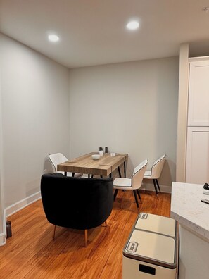 A compact kitchen with a wooden table, white chairs, a black chair, and a vintage-style refrigerator. - Furnished luxury apt, pool, sauna, great location (Los Angeles)
