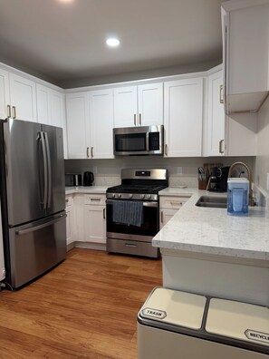 A modern kitchen with white cabinets, stainless steel appliances, and a marble countertop. - Furnished luxury apt, pool, sauna, great location (Los Angeles)