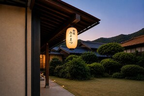 A traditional Japanese building with a sign in Japanese, surrounded by greenery and hills in the background. - Open special price / Shodoshima Island in the Seto Inland Sea / Shikai with a view of the beauty of many islands / Rental of a building / Grand piano / Tea ceremony room / Welcome drink / Pick-up service at ports and sightseeing spots on request / Free fe (小豆郡土庄町伊喜末)