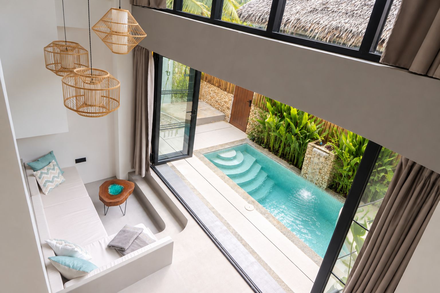 Un interno moderno con piscina, ampie finestre e una zona relax con cuscini.