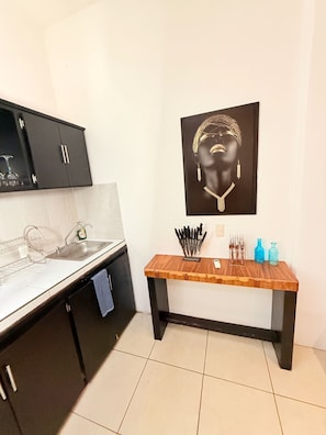 A kitchen with a black cabinet, a wooden countertop, a sink, and a wall-mounted picture. - CONDO W/BALCONY 1 STREET FROM BEACH AND BOARDWALK (Puerto Vallarta)