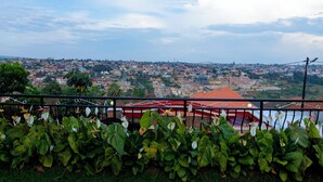 A cityscape with a view of buildings and a red-roofed structure in the foreground. - La Licorne Apartments . Serene 2BR in Kicukiro . Short term & long term Rentals (Kigali)