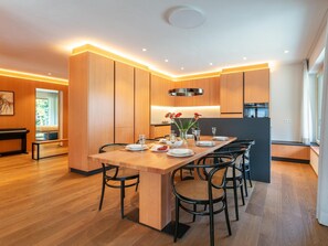 Une cuisine moderne avec des meubles en bois, un îlot central doté de sièges et un coin repas.