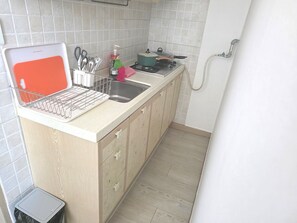Uma cozinha com pia, bancada e fogão.