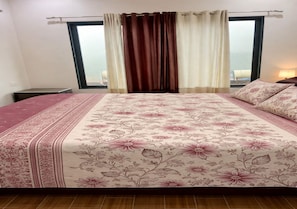 A bedroom with a large bed, a nightstand, a window with curtains, and a view of the outside. - Peaceful 1-bedroom apartment in charming Ruighar perfect for relaxing (Ruighar)