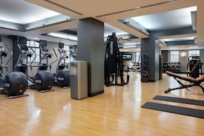 Una palestra con tapis roulant, cyclette e macchinari per l'allenamento con i pesi.