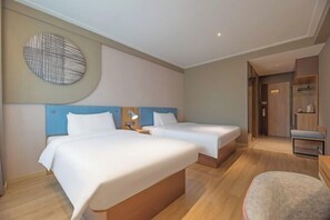 A hotel room with two beds, a round wall decoration, a desk, and a chair. - Home Inn (Xi'an Big Wild Goose Pagoda Xiying Road) (Xi'an)