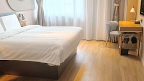 A hotel room with a large bed, a desk with a lamp, a chair, and a small table with a lamp. - Home Inn (Xi'an Big Wild Goose Pagoda Xiying Road) (Xi'an)