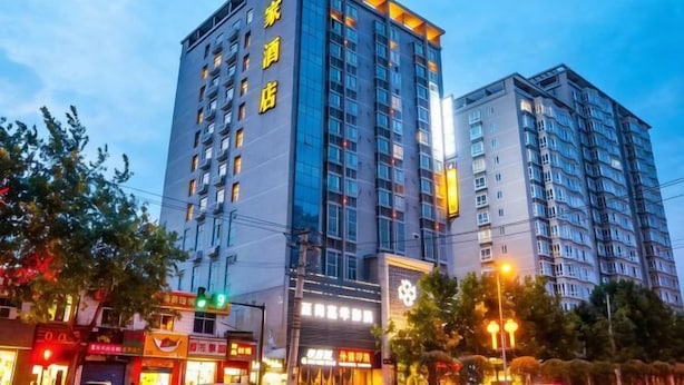 A multi-story hotel with a modern design, featuring a prominent entrance and a large glass facade. - Home Inn (Xi'an Big Wild Goose Pagoda Xiying Road) (Xi'an)