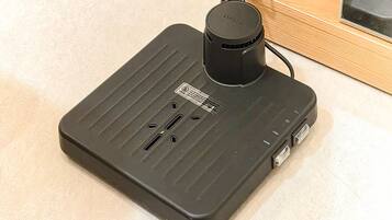 A black portable heater with a control panel, a power cord, and two USB ports.