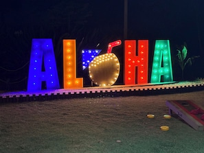 Letras iluminadas que deletrean 'ALOHA' con una bombilla en el centro.