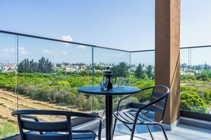 Un balcon avec une table, des chaises et une machine à café.