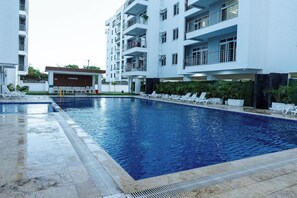 A swimming pool with lounge chairs, a building labeled 'LOUNGE,' and a multi-story residential structure. - 2Bedroom Mombasa Nyali near the beach/AC/swimming pool/Netflix (Mombasa)