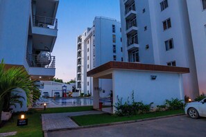 A modern residential building with balconies, a swimming pool, and a gated entrance. - 2Bedroom Mombasa Nyali near the beach/AC/swimming pool/Netflix (Mombasa)