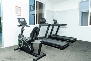 Ein Fitnessraum mit Laufbändern, Crosstrainern und einem stationären Fahrrad.