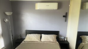 A bedroom with a bed, nightstands, a lamp, an air conditioner, and a mirror. - Cheap Room in Parafield Gardens (Parafield Gardens)