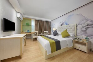 A hotel room with a bed, a desk, a chair, a TV, and a wall mural. - Chengyue International Hotel (Guangzhou)