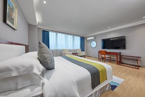 A hotel room with a bed, a desk, a TV, and a window with curtains. - Chengyue International Hotel (Guangzhou)