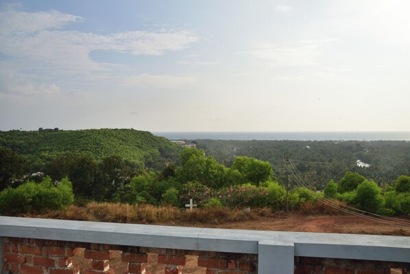 A view from a high vantage point overlooking a hilly landscape with a brick wall in the foreground.