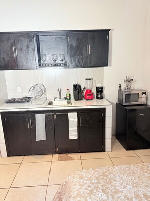 A compact kitchen with a microwave, toaster, and sink. - 2 minutes walk to the boardwalk and 4 to the beach (Puerto Vallarta)