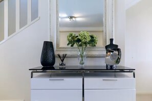 A modern bathroom with a glass shower enclosure, a white sink, and a mirror with a decorative frame. - Modern Town House (East Fremantle)