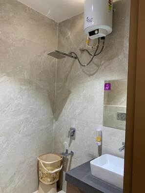A bathroom with a shower, a sink, and a mirror.