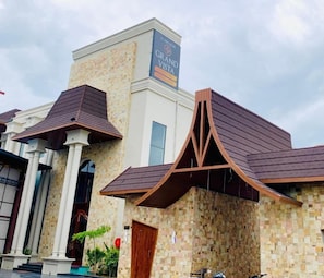 A building with a sign reading 'Grand Vista.' It features a modern architectural design with a prominent triangular structure on the roof.