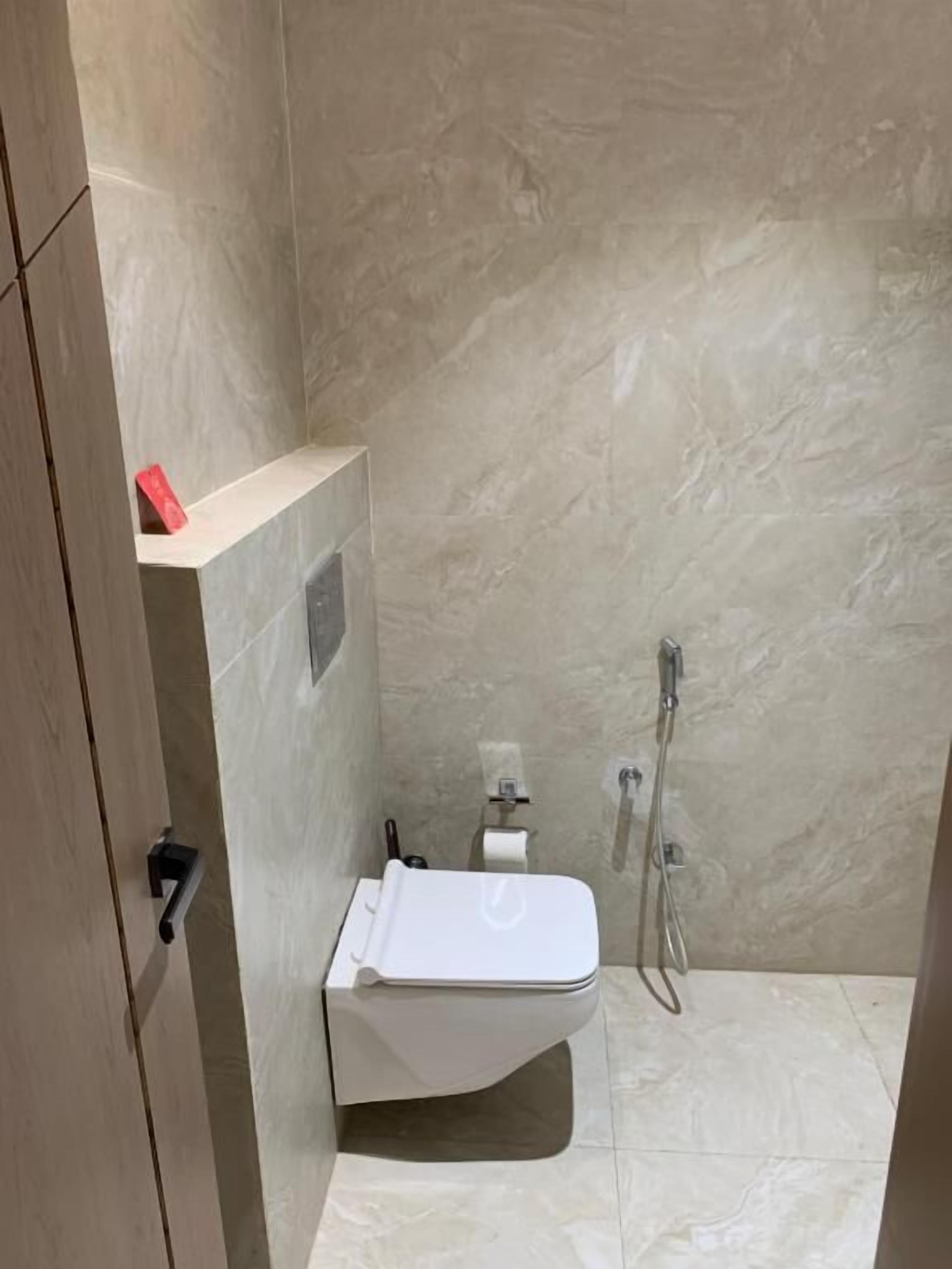 Ein Badezimmer mit Toilette, Dusche und Handtuchhalter.