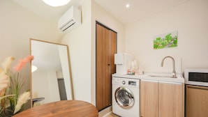 A compact kitchen with a washing machine, a sink, and a microwave. - Stay Log in Sinchon Hongdae (Seoul)