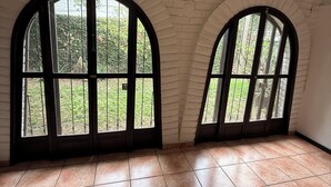 A room with arched windows, white brick walls, and tiled flooring. - Loma Linda Essenz. 152B (San Salvador)