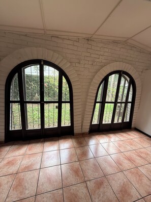 A room with arched windows, white brick walls, and tiled flooring. - Loma Linda Essenz. 152B (San Salvador)