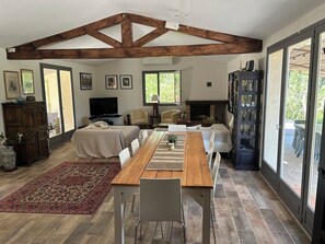 Ein geräumiger Wohnbereich mit einem Holzessttisch, Sofas und einem Kamin.