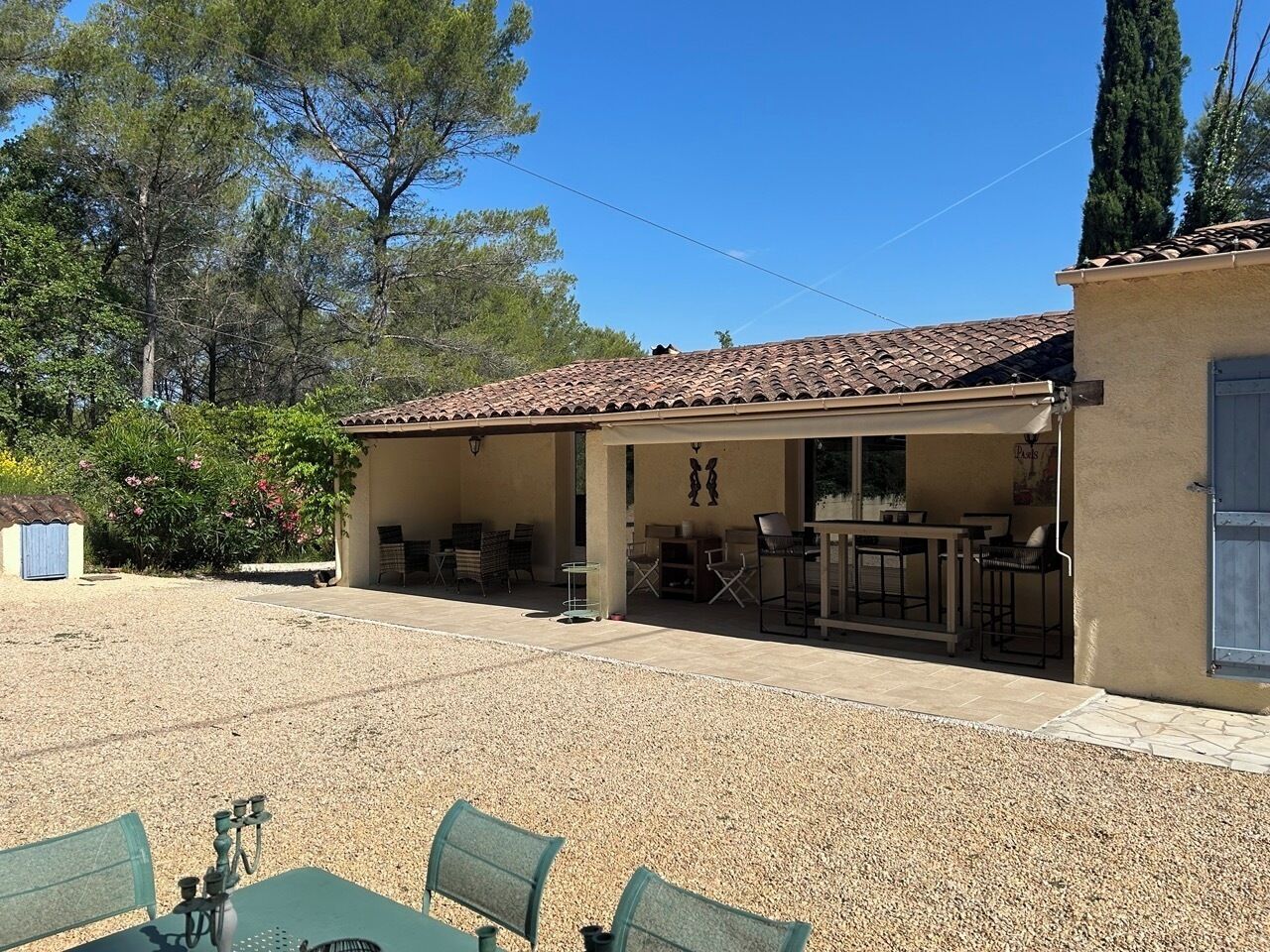 A building with a tiled roof, outdoor seating area, and a gravel ground.