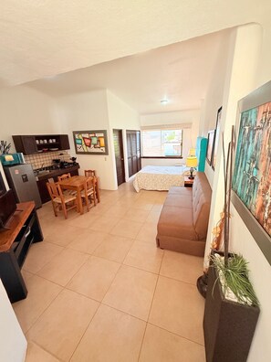 A compact living space with a kitchenette, a dining area, a bed, and a sofa. - 2 minutes walk to the boardwalk and 4 to the beach (Puerto Vallarta)