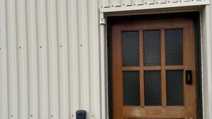 A wooden door with a glass panel, a metal door frame, and a small black device on the wall. - Ocean view in delightful Borgarnes with cool views and environment (Borgarnes)