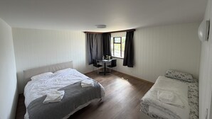 A bedroom with a bed, a desk, and a window. - Ocean view in delightful Borgarnes with cool views and environment (Borgarnes)