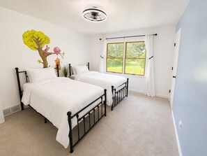 A bedroom with two beds, a ceiling fan, a window with curtains, and a wall mural. - Peaceful Tree-Lined Retreat Near Cleveland (North Olmsted)