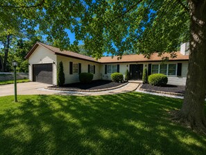 A single-story house with a garage, a front porch, and a well-maintained lawn. - Peaceful Tree-Lined Retreat Near Cleveland (North Olmsted)