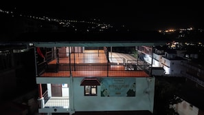 Un hotel con balcón, un cartel que indica 'Royal Luxury Stay' y vistas del entorno nocturno.