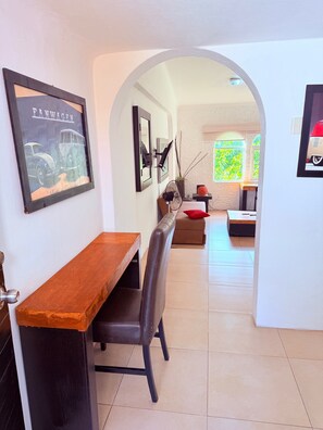 A dining area with a wooden bench, a black chair, and a framed picture on the wall. - 2 minutes walk to the boardwalk and 4 to the beach (Puerto Vallarta)