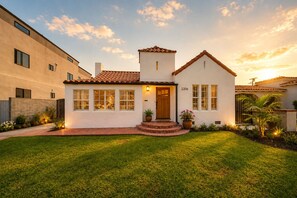 A single-story house with a tiled roof, a front porch, and a well-maintained lawn. - Charming Spanish Retreat Near SoFi Stadium & LAX (Inglewood)