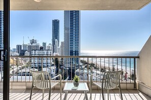 A balcony with two chairs, a small table, and a potted plant. - Surf & Sunrise Beachfront Hideaway by Inn Paradise (Surfers Paradise)