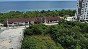 A hotel with multiple buildings, a basketball court, and a view of the ocean.