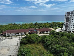 Un hotel con varias construcciones, una cancha de baloncesto y vista al océano.