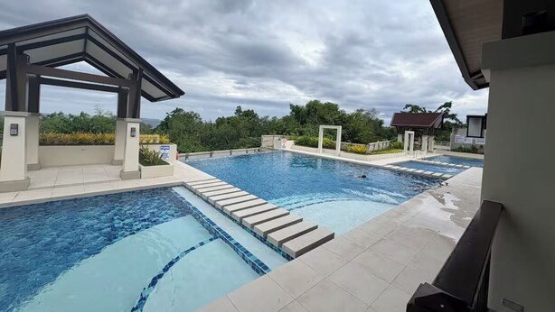 A swimming pool with a covered area and a view of the surrounding landscape.