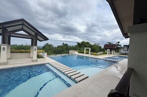 Une piscine dotée d’un espace couvert et offrant une vue sur le paysage environnant.