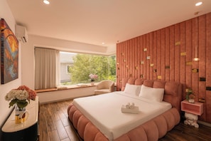A modern bedroom with a large bed, a window with curtains, a bedside table with a vase of flowers, and a wall-mounted air conditioner. - D2 Center Pool Villa with 6 bedrooms (An Khanh Ward)