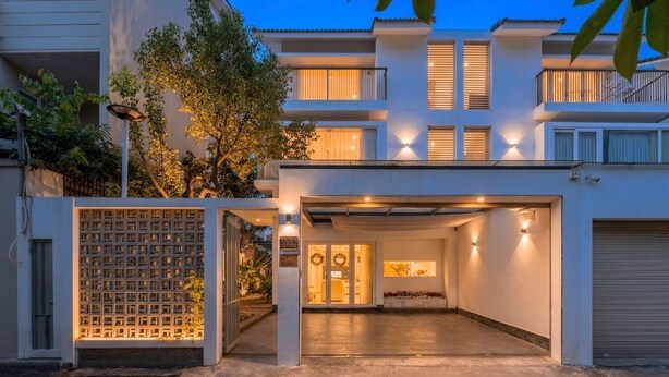 Une maison moderne à deux étages, dotée d’une allée couverte et d’un garage.