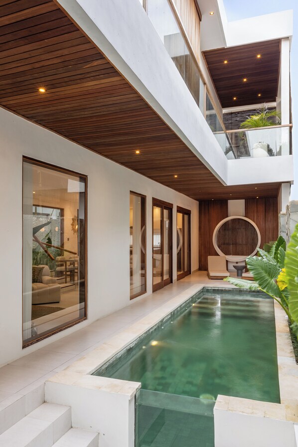 A modern house with a swimming pool, large windows, and a wooden ceiling. - Villa Albizia - 2BR private pool villa near Canggu (Mengwi)